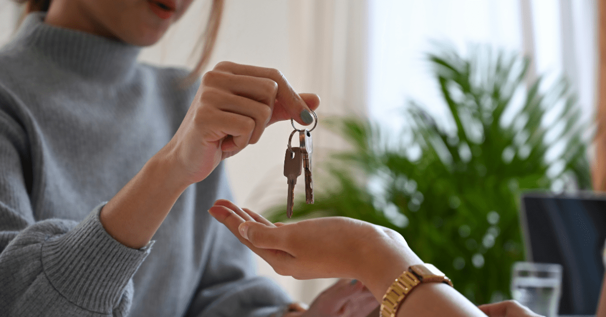 Woman holding out a set of keys to someone else