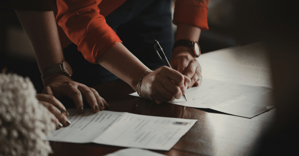 Woman signing paperwork on a table