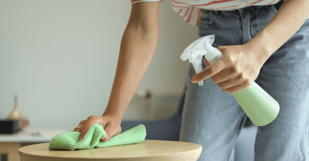 Cleaning the surface of furniture with a spray bottle and cloth