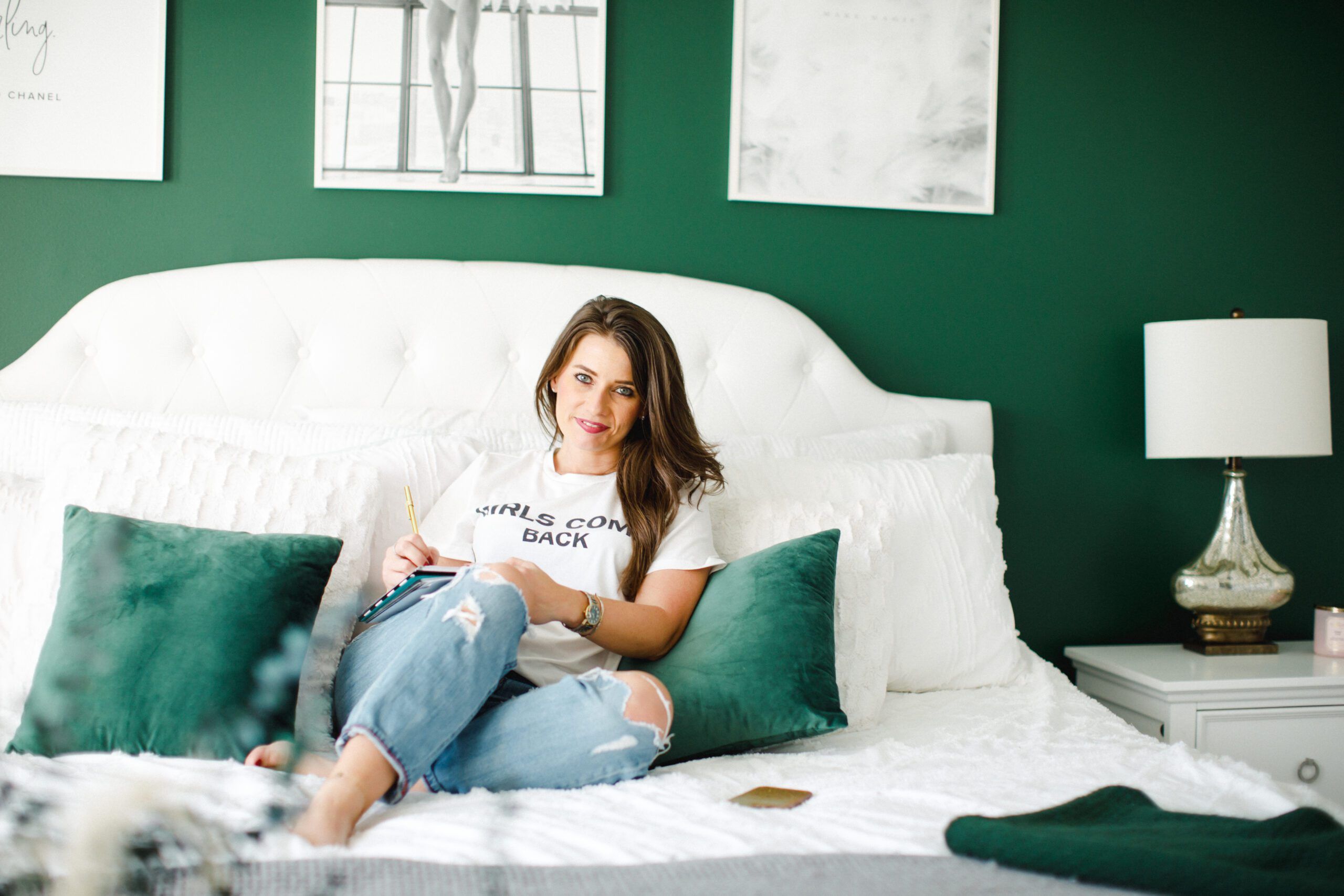 Woman lounging on bed in a freshly decorated room after her divorce; the walls agre green with white accents