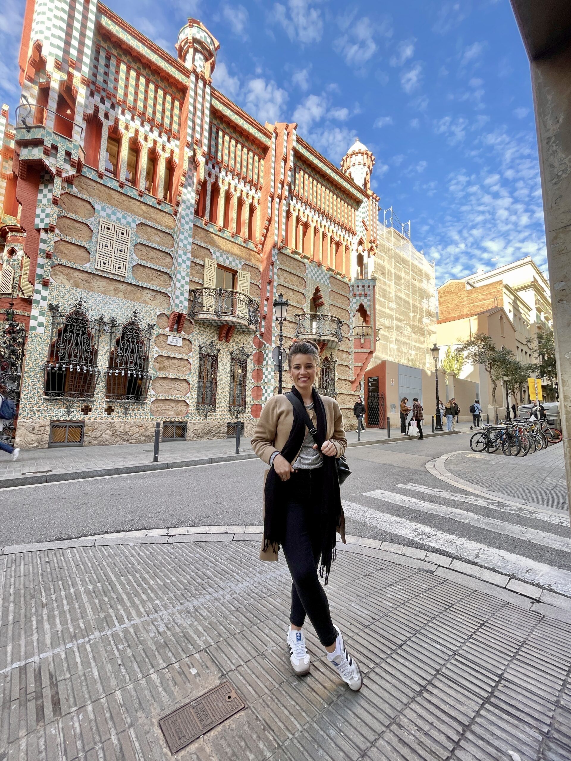 Solo woman traveler in Barcelona, posing in front of a building