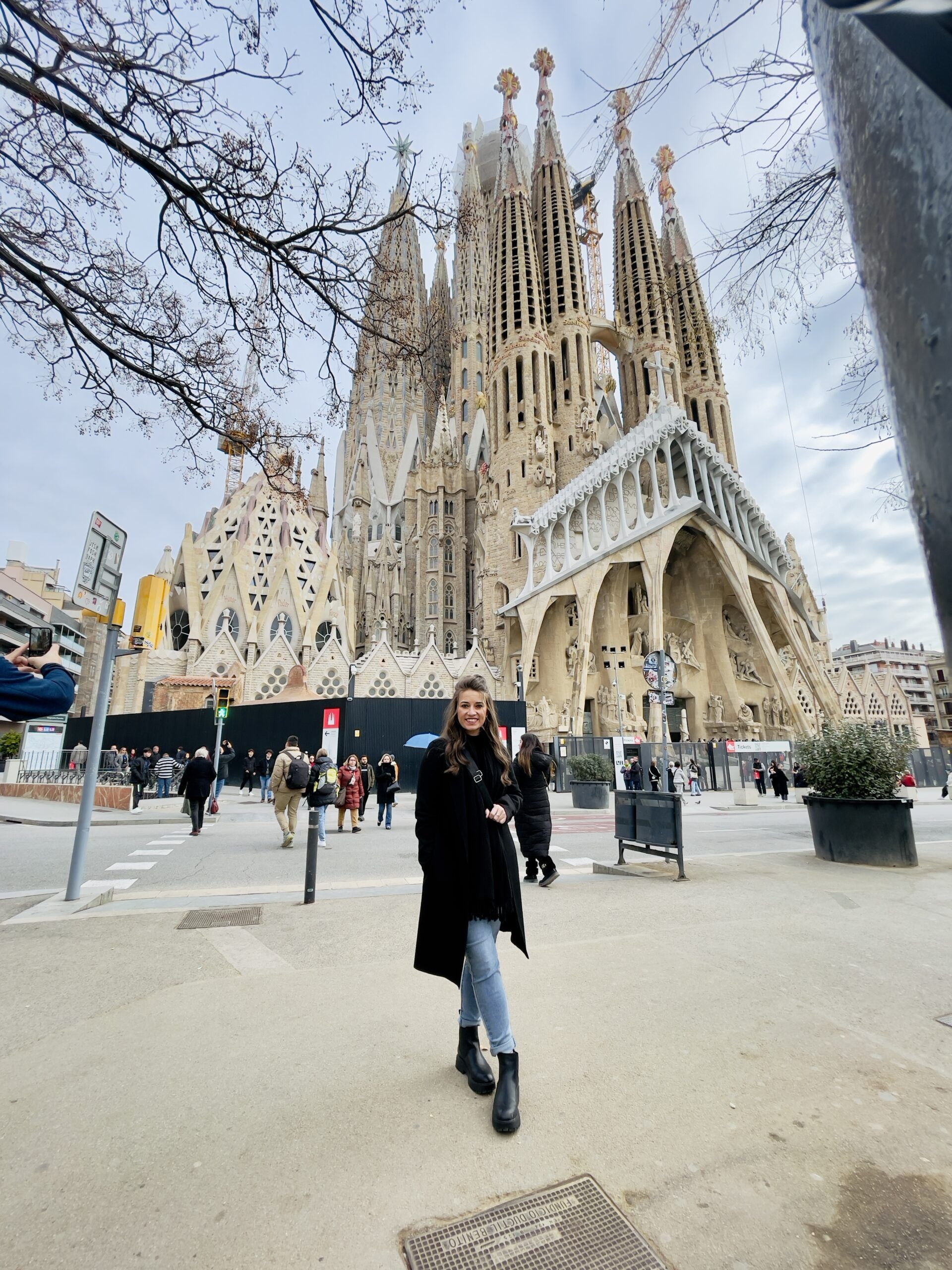 Woman standing in front of La Sagrada Familia in Barcelona during a solo trip