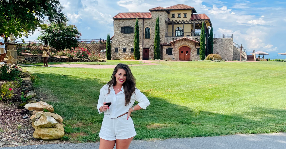 Jamie Milam standing outside a winery on a sunny day during a weekend getaway near Charlotte