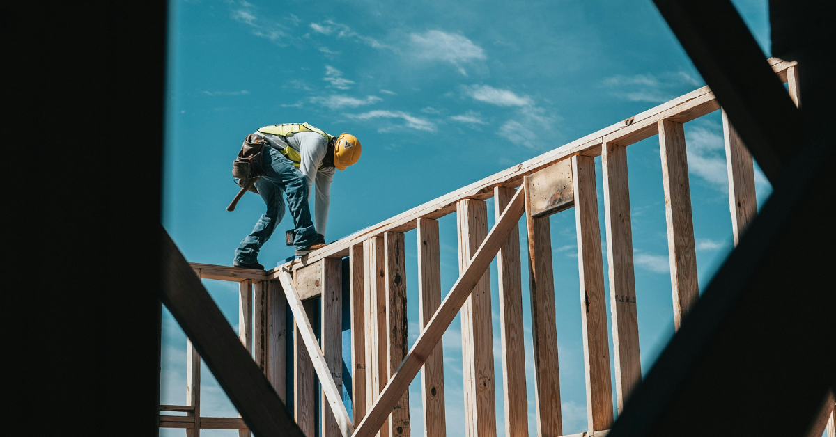 Image of a worker on top of the framing of a new construction home