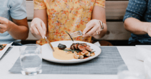 Image of a woman eating a steak dinner