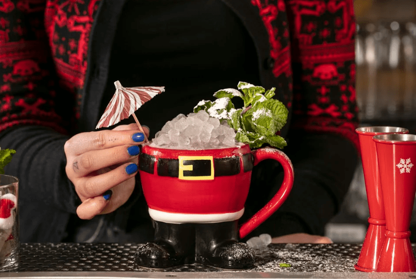 christmas-themed cocktail in a santa claus cup