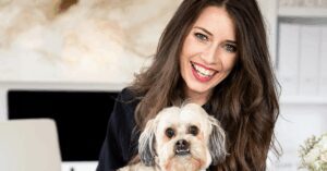 Image of Jamie Milam, a woman with dark hair, holding her pet dog
