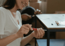 Woman screwing a table together by hand.