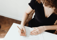 A woman signing paperwork