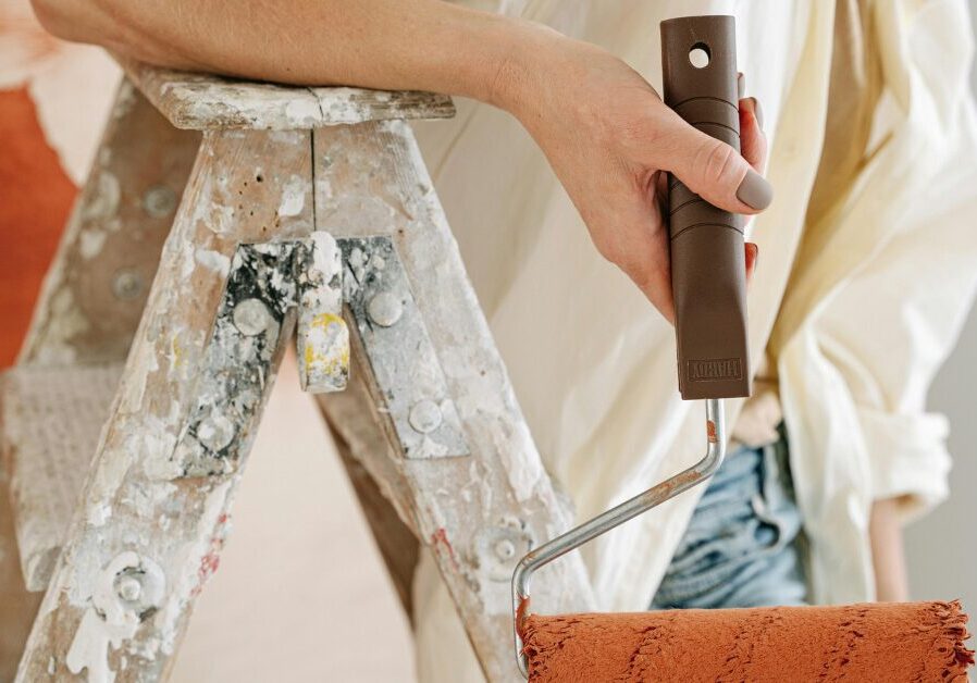 Remodeling Projects with the Best ROI_ What Actually Makes an Impact, from a Charlotte Realtor (2) Someone holding a paint roller and standing on a ladder