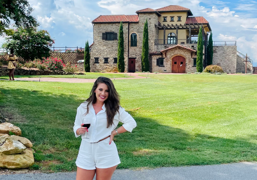 Jamie Milam standing outside a winery on a sunny day during a weekend getaway near Charlotte